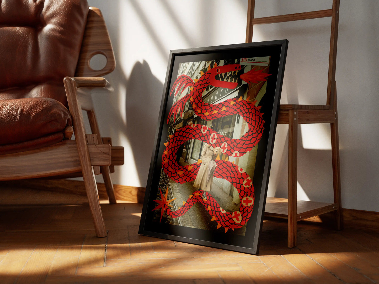Framed artwork of a Lucerne street scene with a woman, her dog, and a large illustrated red dragon. By NYC Artist Max Kolo. The frame is leaning on a wooden floor with a chair and ladder in the background