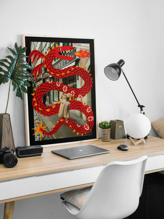 Modern office desk with a large framed artwork of a red dragon illustrated by NYC based artist Max Kolo, a laptop, and decorative items.