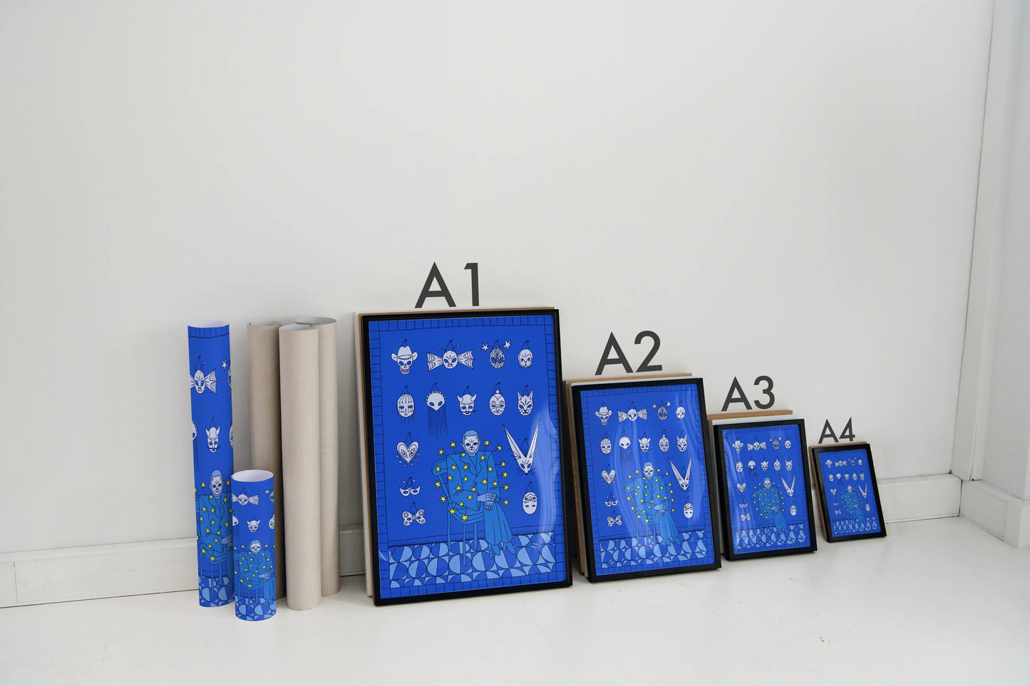 Set of blue framed prints from size A1 to A4 for size comparison, and a cylindrical product on a white surface with a white wall background. Artwork by New York City artist Max Kolo.