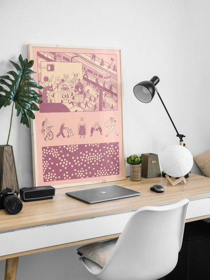Framed “Bug Vision” city illustration poster by NYC artist Max Kolo displayed on a modern white desk setup, featuring stylized insect characters commuting through a bustling urban scene in bold pink and purple panels.