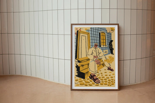 Framed ‘Lisbon’ city illustration poster by NYC artist Max Kolo resting on a curved white tiled wall, featuring a stylized local Lisbon man sitting on sunlit stone steps in warm yellow and blue tones.