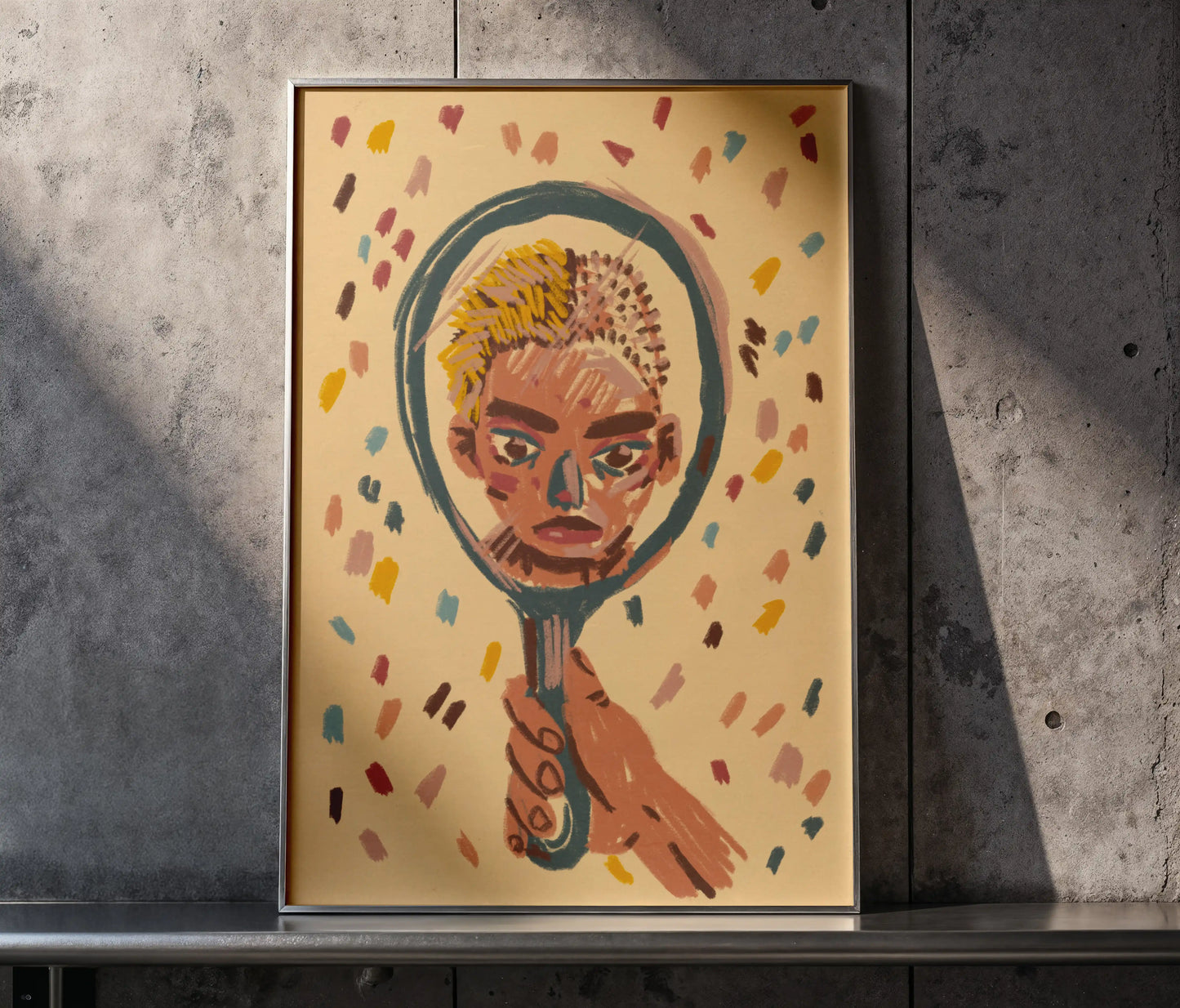Framed ‘Mirror’ art print by Max Kolo displayed against a textured concrete wall, featuring a stylized painted face inside a hand-held mirror with colorful abstract accents.